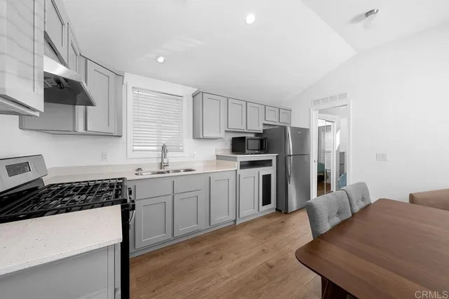 a kitchen with granite countertop a sink stainless steel appliances and cabinets