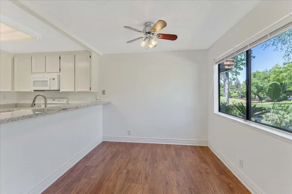 a view of a kitchen with wooden floor and a window