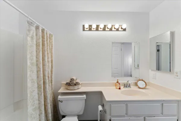 a bathroom with a sink a toilet and a mirror