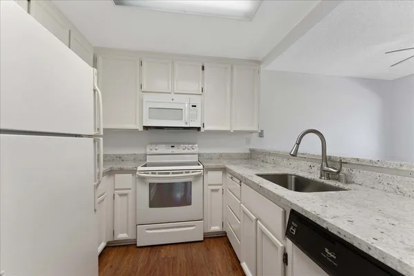 a kitchen with white cabinets stainless steel appliances and sink