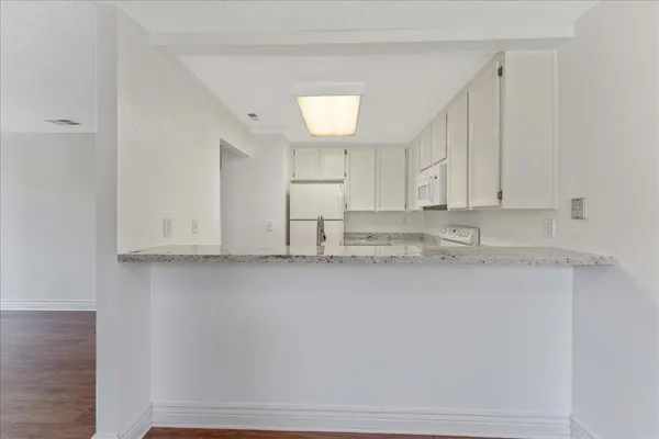 a view of kitchen with granite countertop cabinets