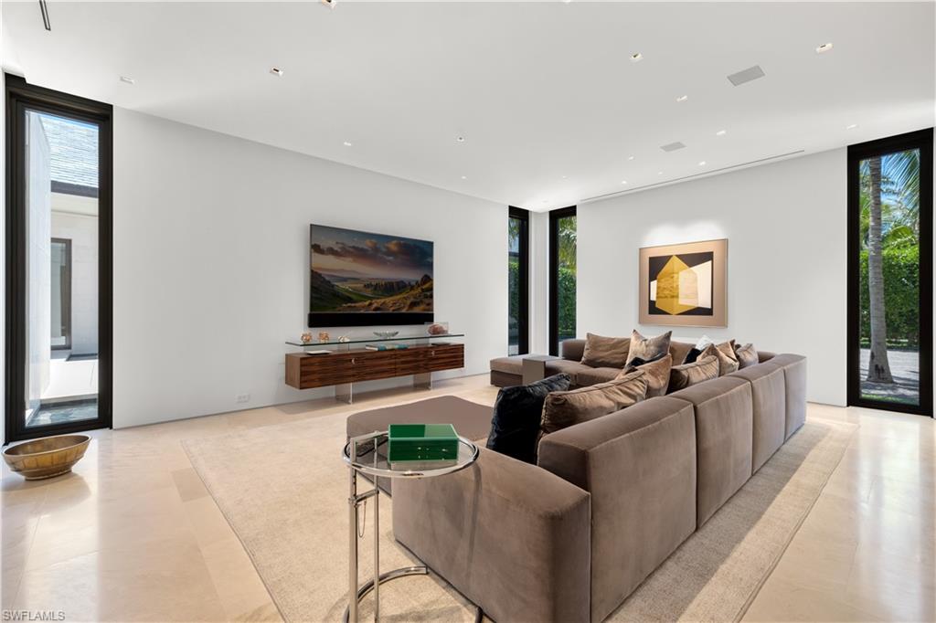 3655 Fort Charles Drive Naples, FL 34102 - Photo 12 of 50 a living room with furniture and a flat screen tv