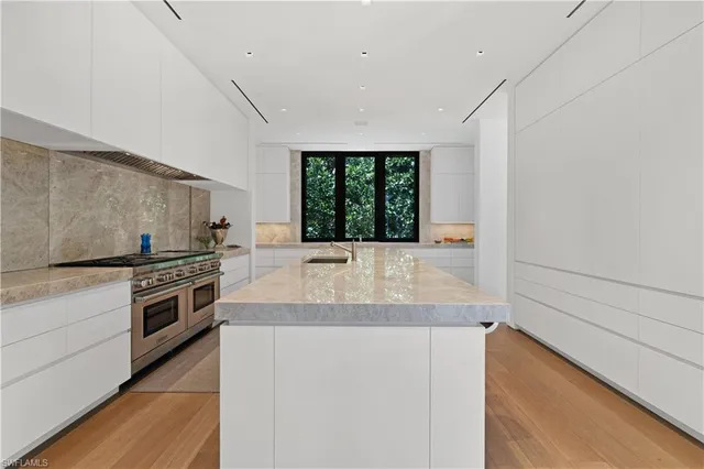 a large white kitchen with a large window