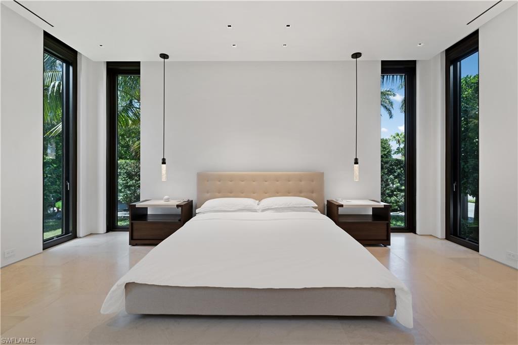 3655 Fort Charles Drive Naples, FL 34102 - Photo 16 of 50 a large bed sitting in a bedroom next to a window