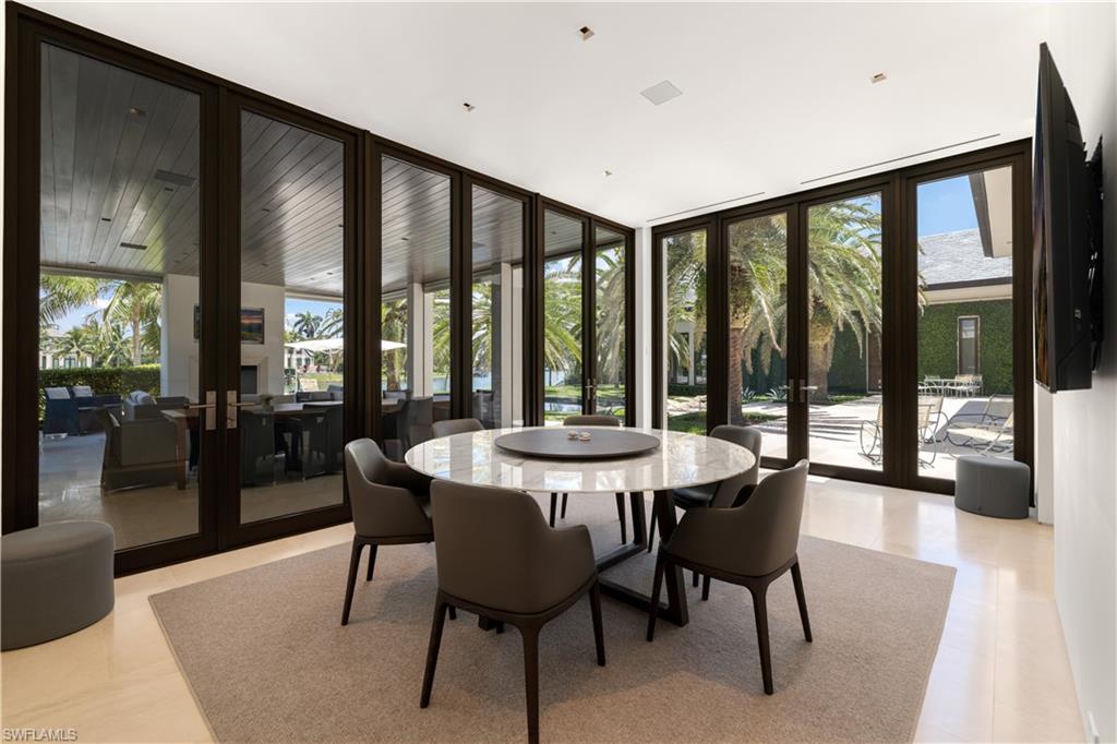 3655 Fort Charles Drive Naples, FL 34102 - Photo 22 of 50 a view of a dining room with furniture and large windows