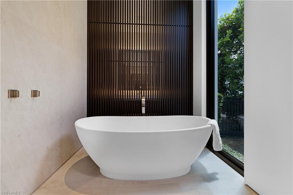 3655 Fort Charles Drive Naples, FL 34102 - Photo 27 of 50 a white bath tub sitting in a bathroom