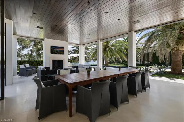 a living room with furniture a fireplace and a floor to ceiling window