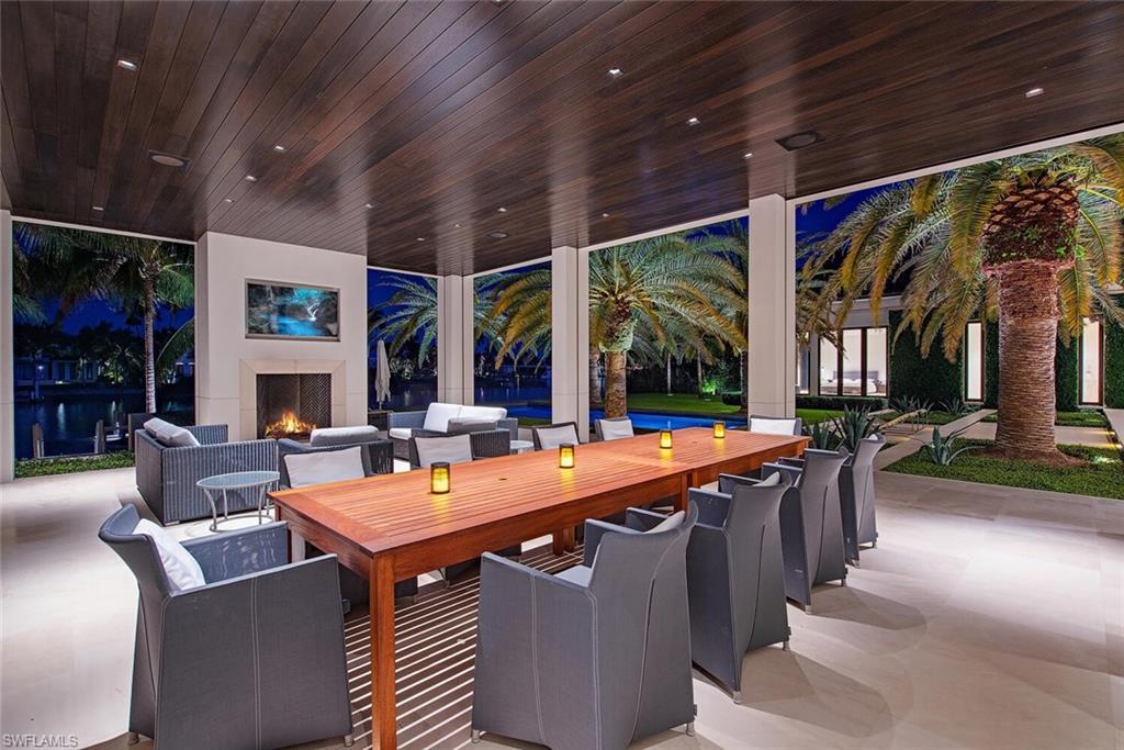 3655 Fort Charles Drive Naples, FL 34102 - Photo 34 of 50 a view of a patio with dining table and chairs