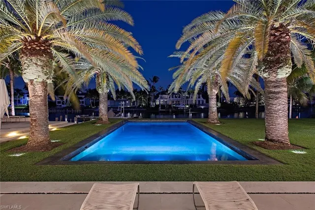 a couple of palm trees in front of yellow house