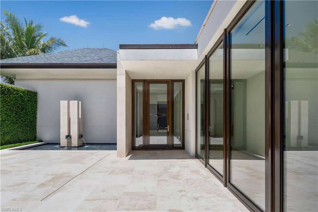 3655 Fort Charles Drive Naples, FL 34102 - Photo 9 of 50 a view of a hallway with wooden walls and door