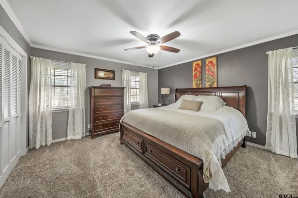 a spacious bedroom with a bed and a chandelier