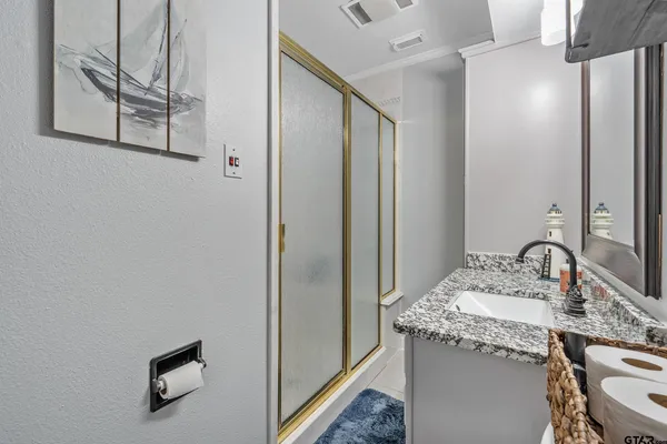 a bathroom with a granite countertop sink and a mirror