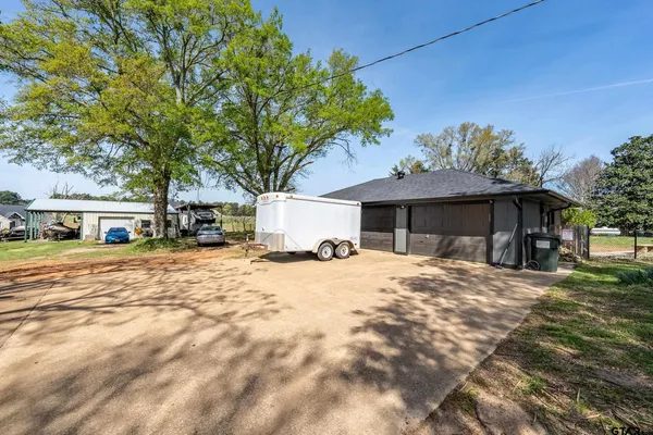a front view of a house with a yard covered with snow and trees