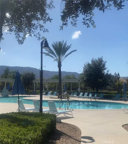 a view of swimming pool with lake view and trees