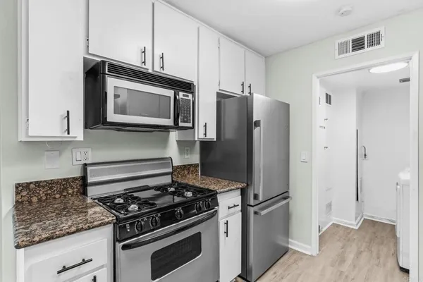 a kitchen with stainless steel appliances and cabinets