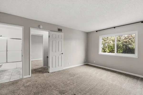 an empty room with windows and closet