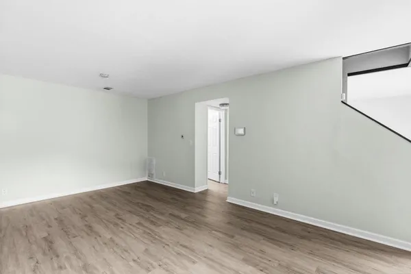 a view of an empty room with wooden floor