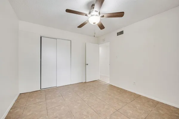 an empty room with chandelier fan