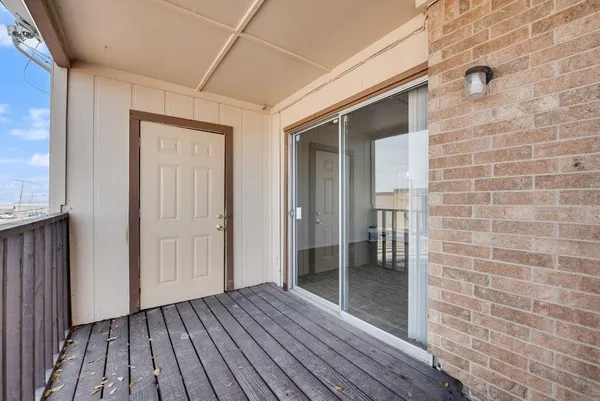 a view of a hallway with wooden floor and a bathroom