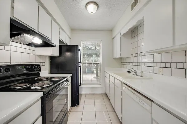 a kitchen with a sink appliances and cabinets