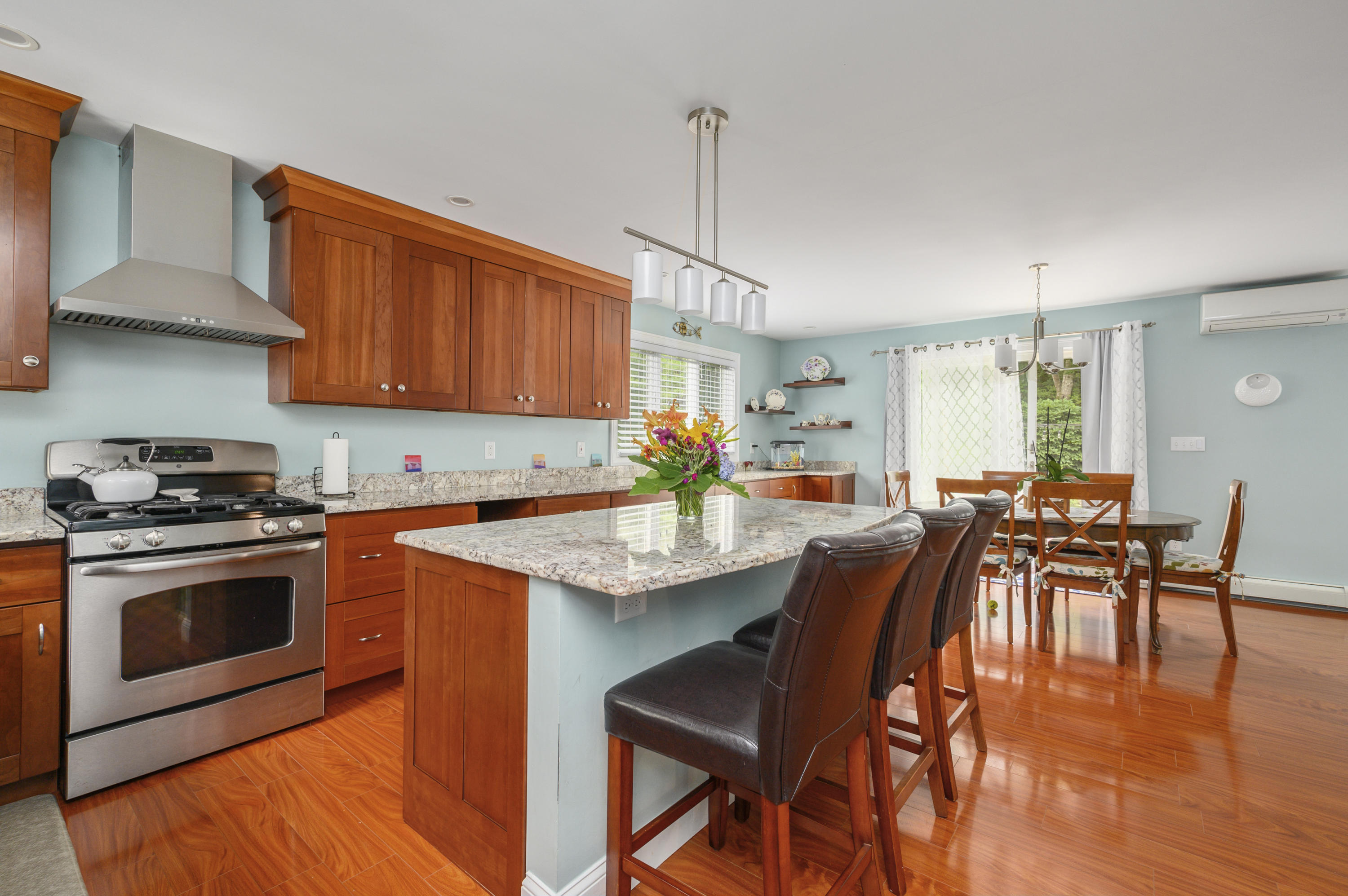 60 Truro Center Road Truro, MA 02666 - Photo 11 of 30 a kitchen with stainless steel appliances granite countertop a stove top oven a sink a dining table and chairs with wooden floor