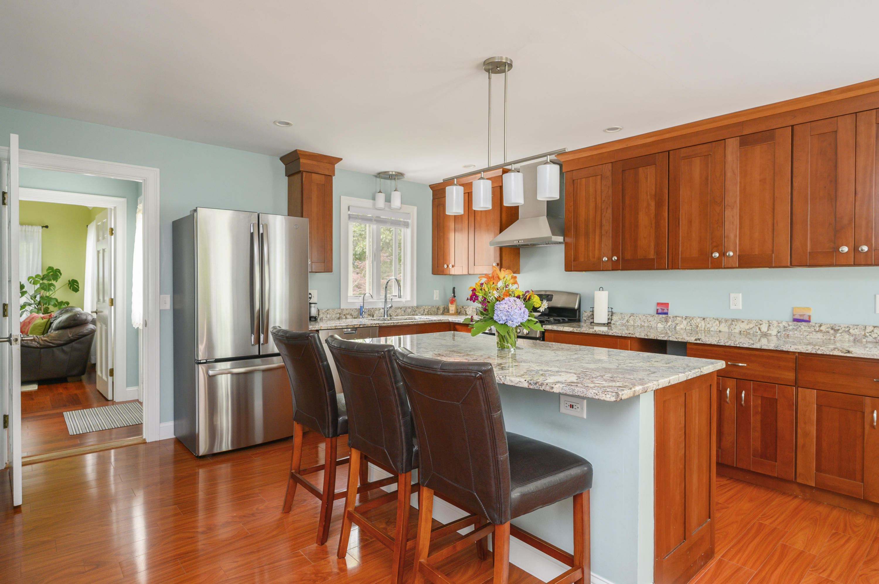 60 Truro Center Road Truro, MA 02666 - Photo 9 of 30 a kitchen with stainless steel appliances granite countertop a refrigerator a sink dishwasher a stove a dining table and chairs with wooden floor
