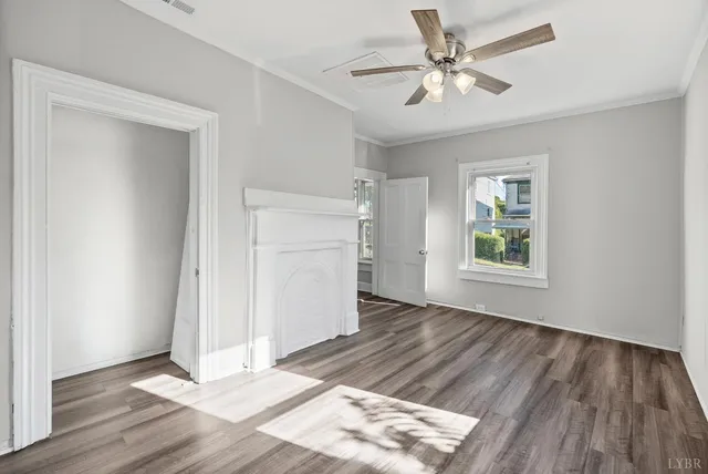 a view of an empty room with window and wooden floor