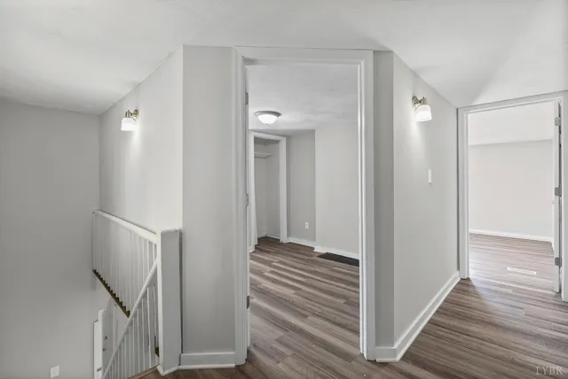 a view of a hallway with wooden floor and staircase