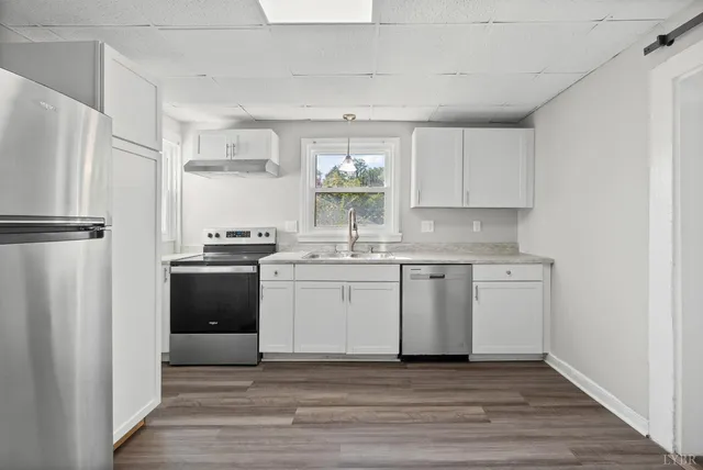 a kitchen with a refrigerator sink and cabinets