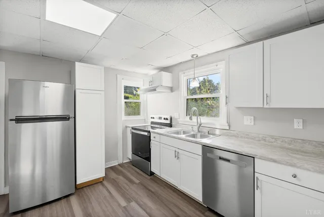 a kitchen with a sink a refrigerator and window