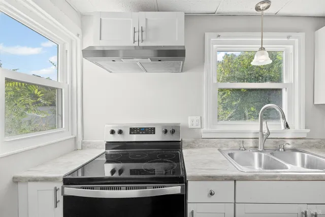 a kitchen with appliances cabinets and a window