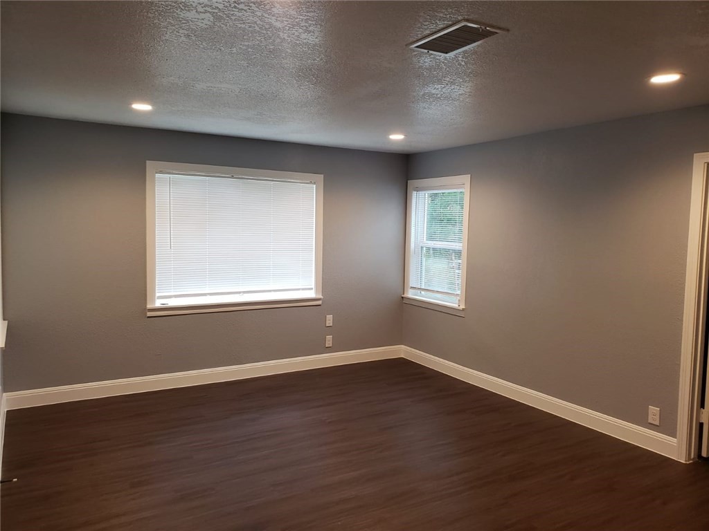 18901 Hogeye Road, Unit A Manor, TX 78653 - Photo 7 of 10 a view of an empty room with wooden floor and a window