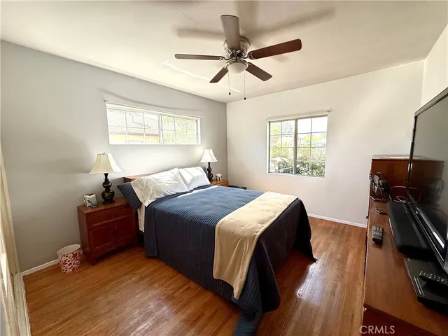 a bedroom with a bed and wooden floor