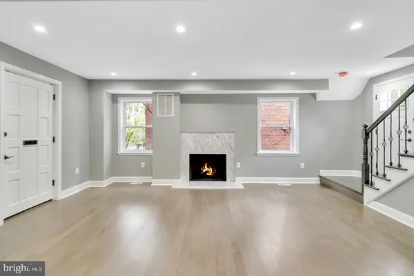 an empty room with windows and a fireplace