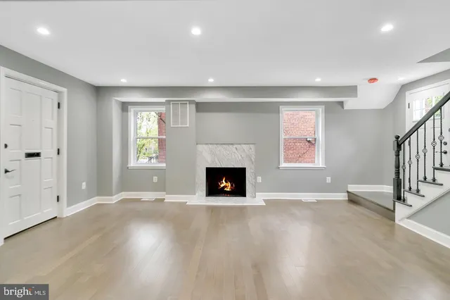 an empty room with windows and a fireplace