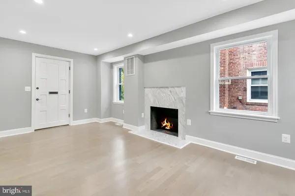 a view of an empty room with a window and fireplace