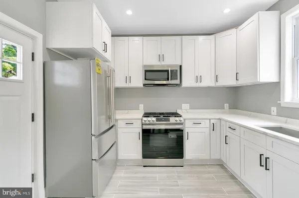 a kitchen with cabinets stainless steel appliances and a sink