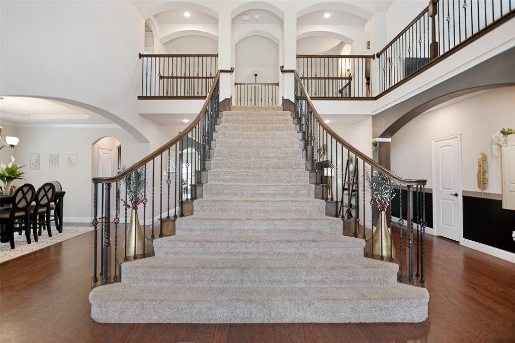 413 Frontier Court Midlothian, TX 76065 - Photo 2 of 26 Grand straight staircase with flared wrought iron railing and wood handrails.