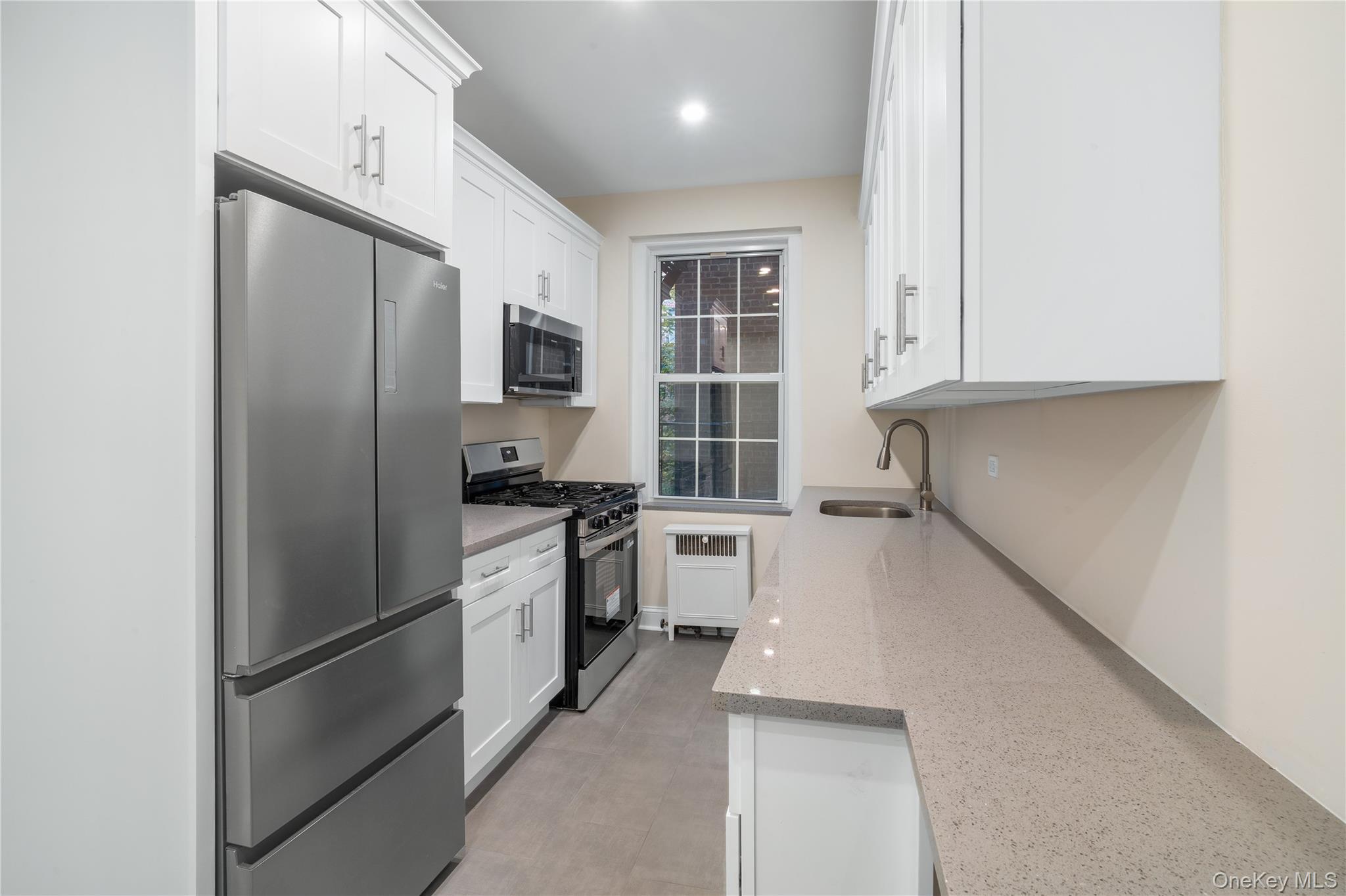 110-07 73rd Road, Unit 3K Queens, NY 11375 - Photo 12 of 21 a kitchen with a refrigerator and a sink