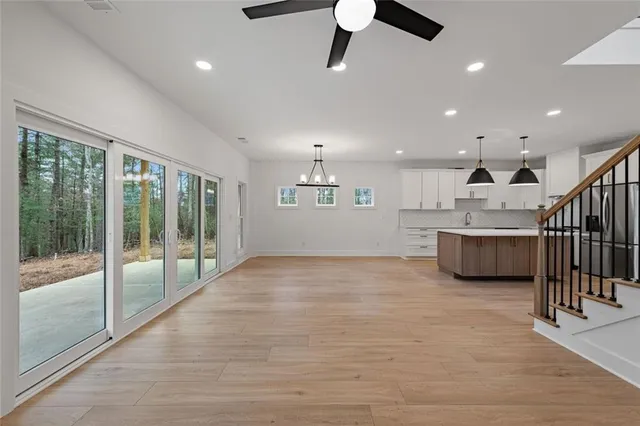 a kitchen with stainless steel appliances granite countertop a sink a stove and a wooden floors