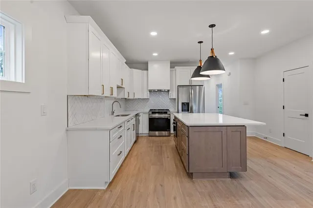 a kitchen with kitchen island a stove a refrigerator and cabinets