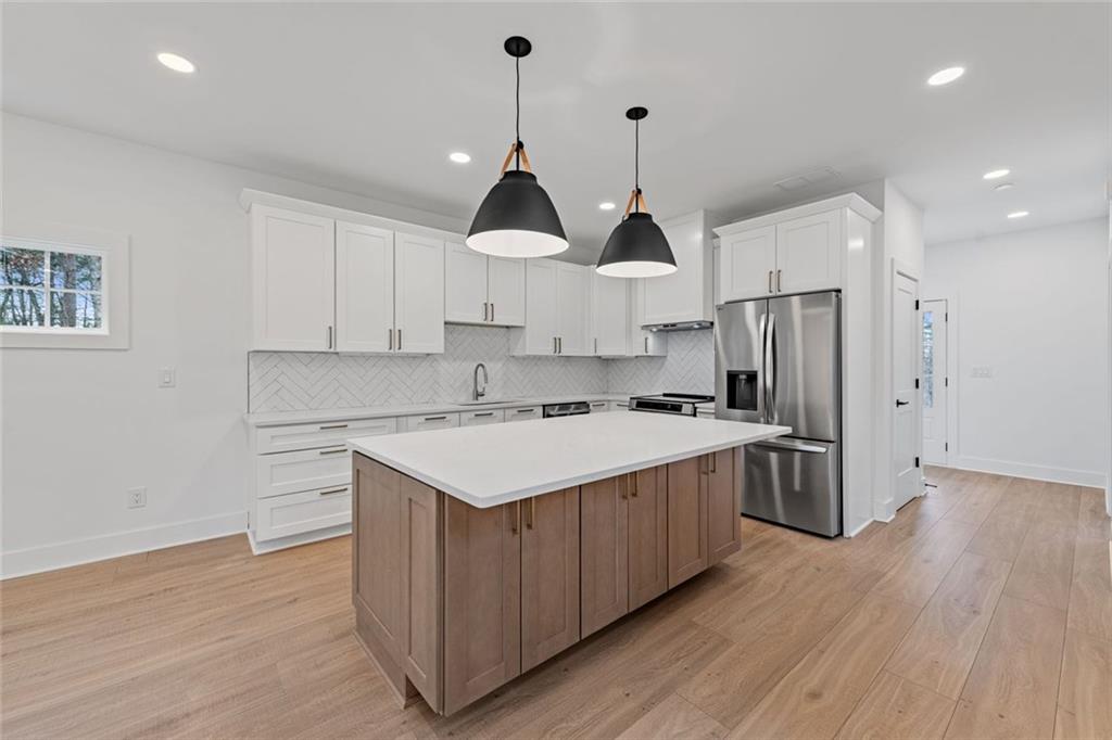 56 Running Brooke Court Morganton, GA 30560 - Photo 14 of 46 a kitchen with stainless steel appliances a sink a stove a refrigerator and white cabinets with wooden floor