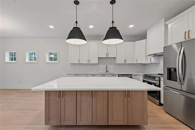 a kitchen that has a sink stainless steel appliances a counter space and a window