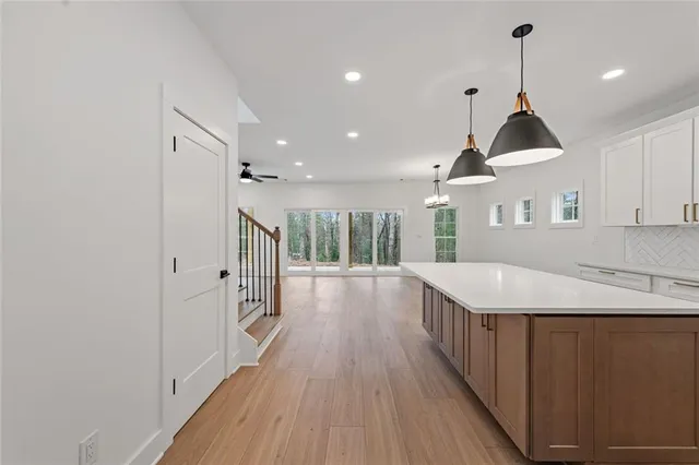 a view of a room with wooden floor stairs and a chandelier