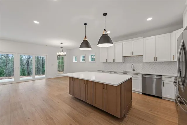 an empty room with wooden floor windows and a ceiling fan