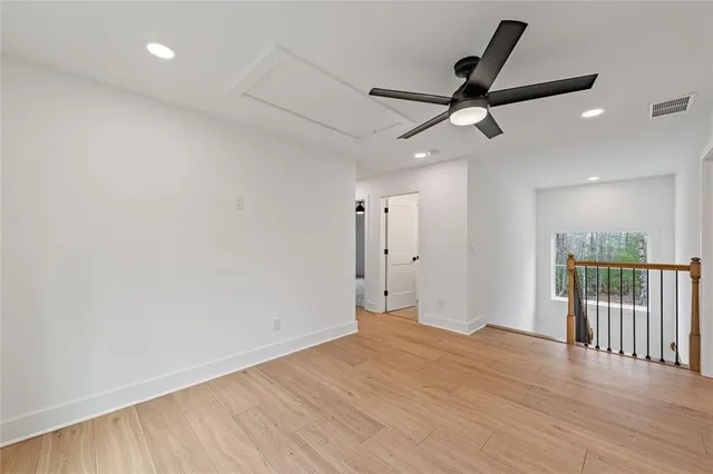 an empty room with a ceiling fan and windows