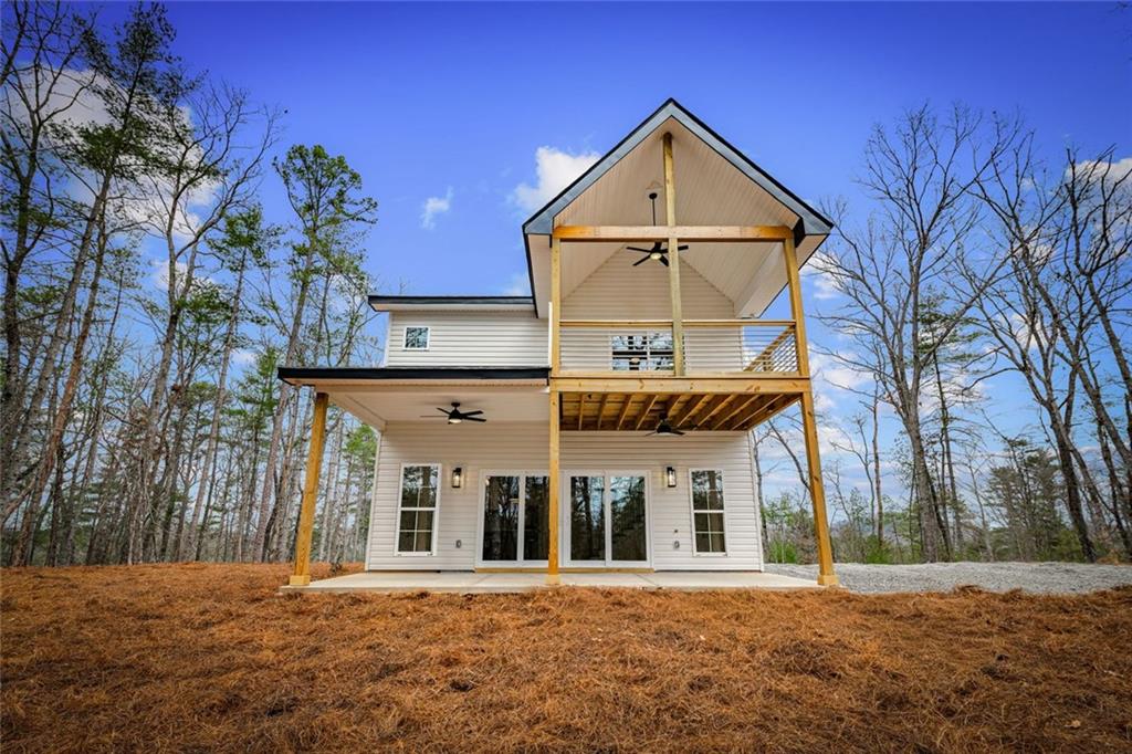 56 Running Brooke Court Morganton, GA 30560 - Photo 5 of 46 a view of a white house with a large windows and a large tree with wooden fence