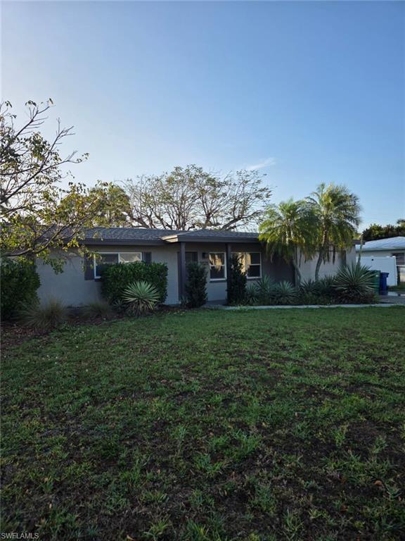 a front view of a house with a yard and potted plants