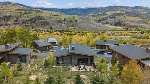 an aerial view of a house with a mountain