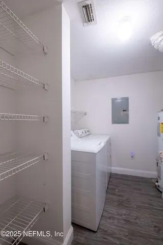a view of an empty room with wooden floor and a ceiling fan